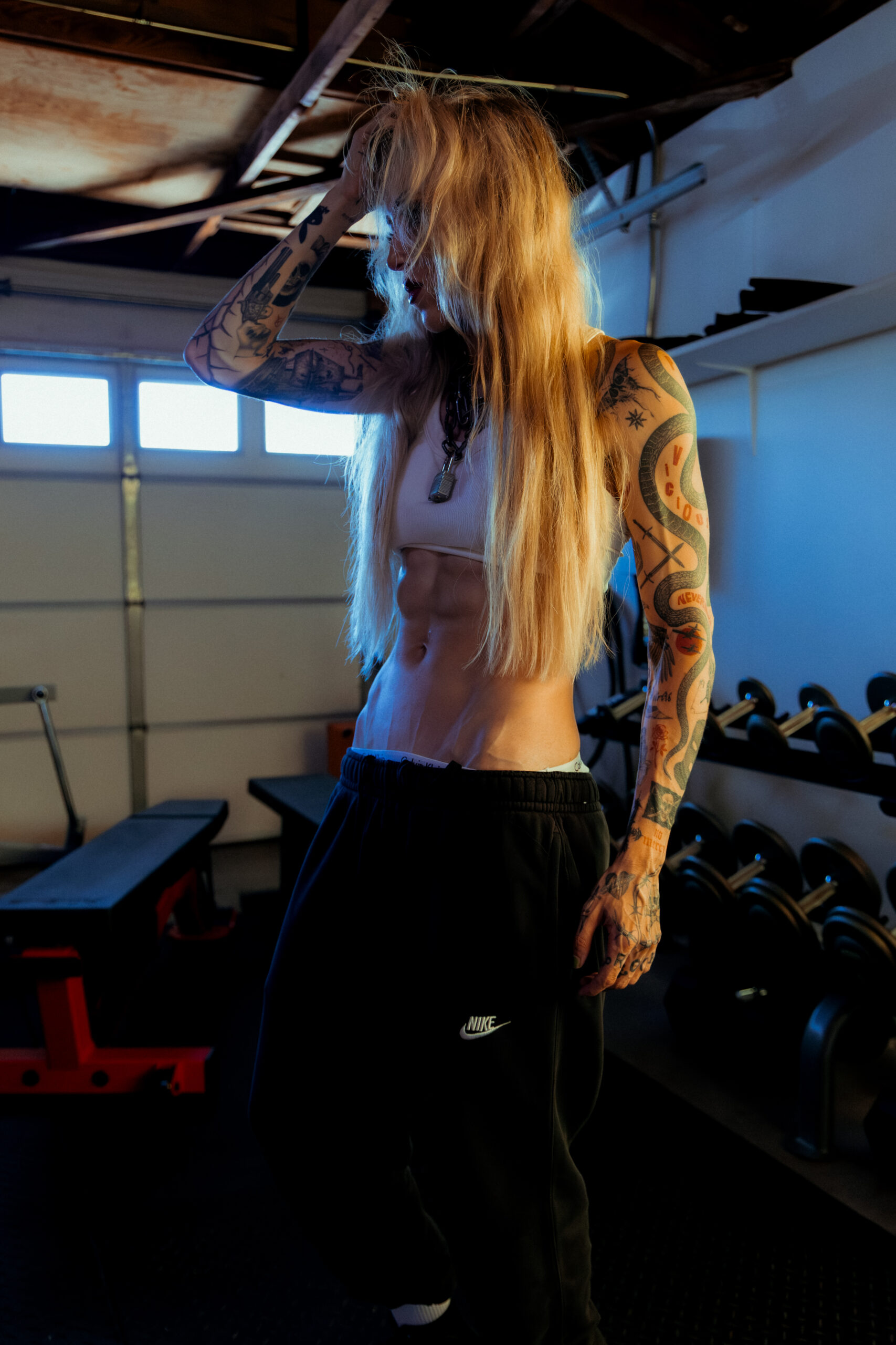 Female physique coach with visible abdominal definition demonstrating camera-ready conditioning in a private training studio.